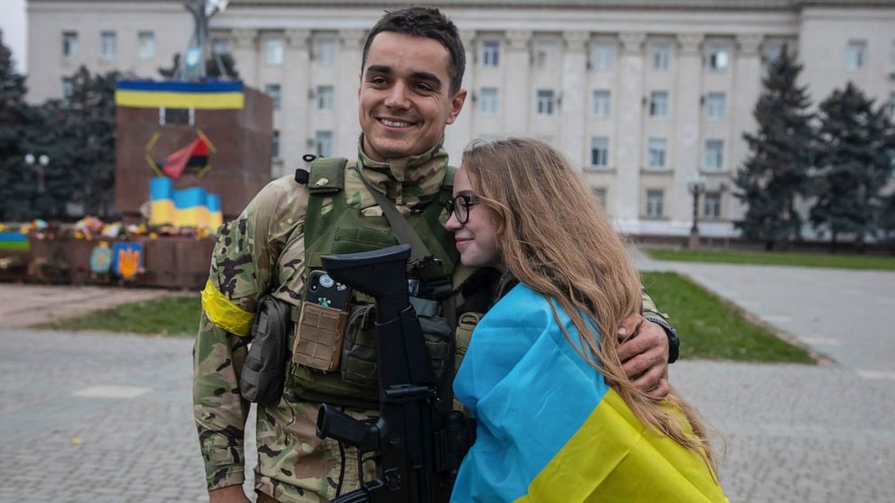 A girl and Ukrainian officer hug as they celebrate the recapturing in Kherson, Ukraine, Saturday, Nov. 12, 2022. People across Ukraine awoke from a night of jubilant celebrating after the Kremlin announced its troops had withdrawn to the other side o