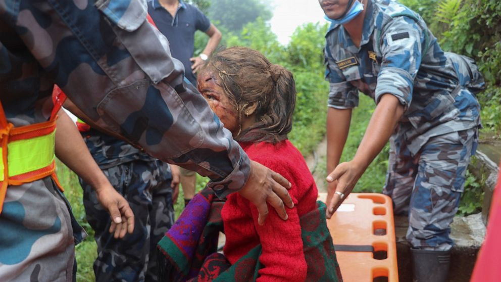 An injured girl is rescued after a landslide stuck early Sunday in Sindhupalchowk district, about 120 kilometers (75 miles) east of the capital, Kathmandu, Nepal, Monday, Sept.14, 2020. Rescuers resumed searching on Monday for people missing since a 