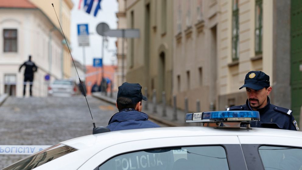 Police officers block the way to the Croatian parliament building near the site of shooting in Zagreb, Croatia, Monday Oct. 12, 2020. A gunman on Monday shot and wounded a police officer outside the Croatian government headquarters in the capital, Za