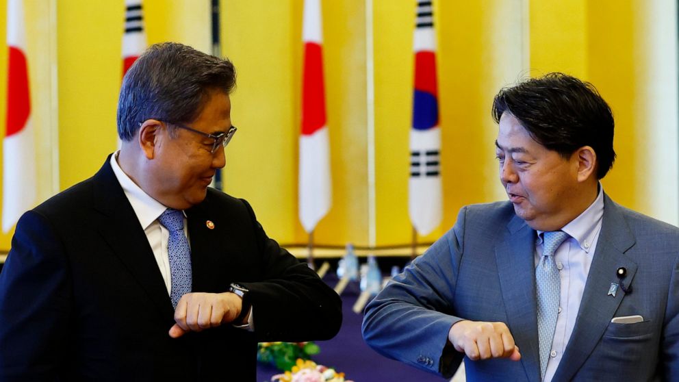 South Korean Foreign Minister Park Jin, left, and Japanese counterpart Yoshimasa Hayashi bump elbows before their talks in Tokyo, Monday, July 18, 2022. (Kim Kyung-Hoon/Pool Photo via AP)