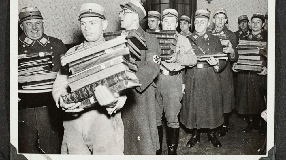 This photo released by Yad Vashem, World Holocaust Remembrance Center, shows German Nazis carry Jewish books, presumably for burning, during Kristallnacht intake most likely in the town of Fuerth, Germany on Nov. 10, 1938. The photos were taken by Na