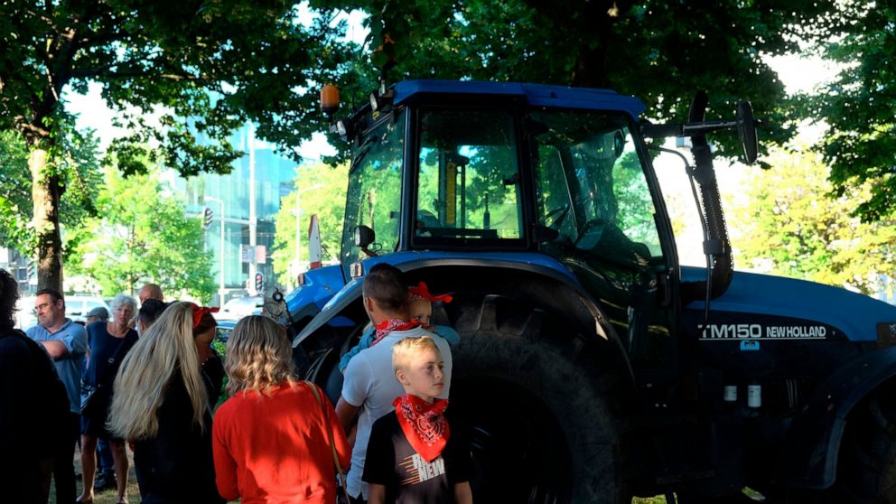 A small group of people gather ahead of a major protest by farmers at a village in central Netherlands, in The Hague, Netherlands, Wednesday, June 22, 2022. Thousands of farmers are driving their tractors along roads and highways across the Netherlan