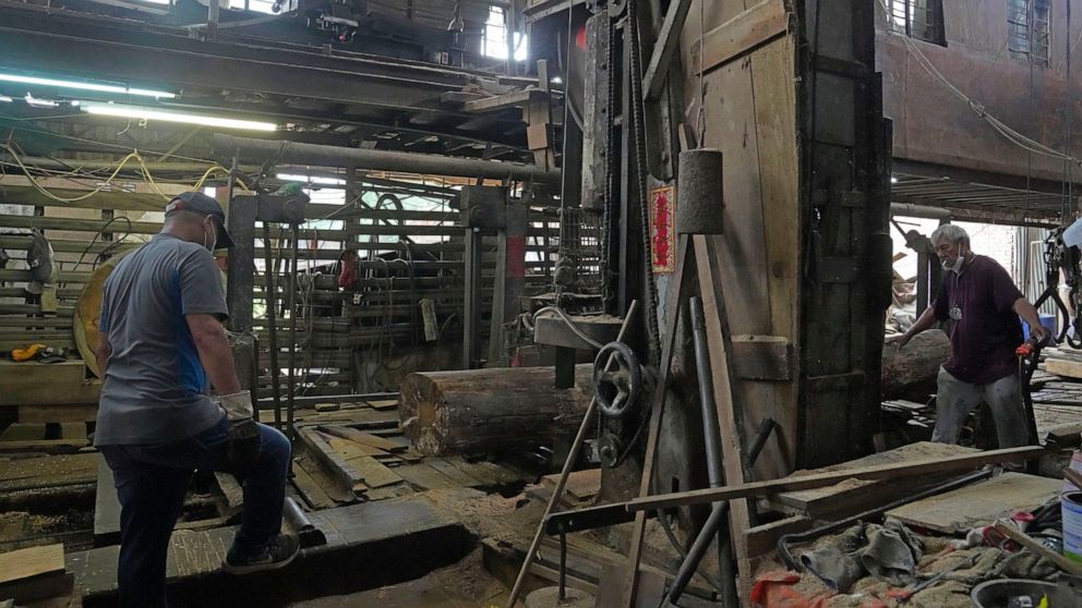 Workers cut the wood in the Chi Kee Sawmill & Timber in Hong Kong, Tuesday, July 12, 2022. Chi Kee Sawmill & Timber, Hong Kong's last operating sawmill, has operated in the city for nearly four decades. But soon, the sawmill could be forced to shut d