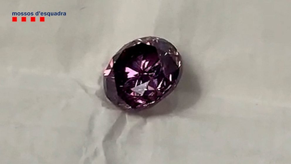 In this photo provided by the Mossos d' esquadra police force of Catalonia, on Thursday Feb. 18, 2021, a diamond is displayed at an unknown location in Spain. A suspected gang of diamond thieves who posed as potential buyers to heist a purple-colored