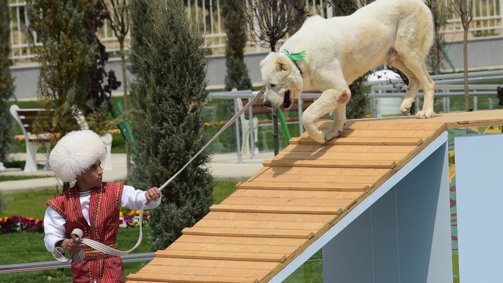 A man dressed in a national costume performs with his border guard shepherd dog Alabay during Dog Day celebration in Ashgabat, Turkmenistan, Sunday, April 25, 2021. The Central Asian nation of Turkmenistan has celebrated its new state holiday honorin