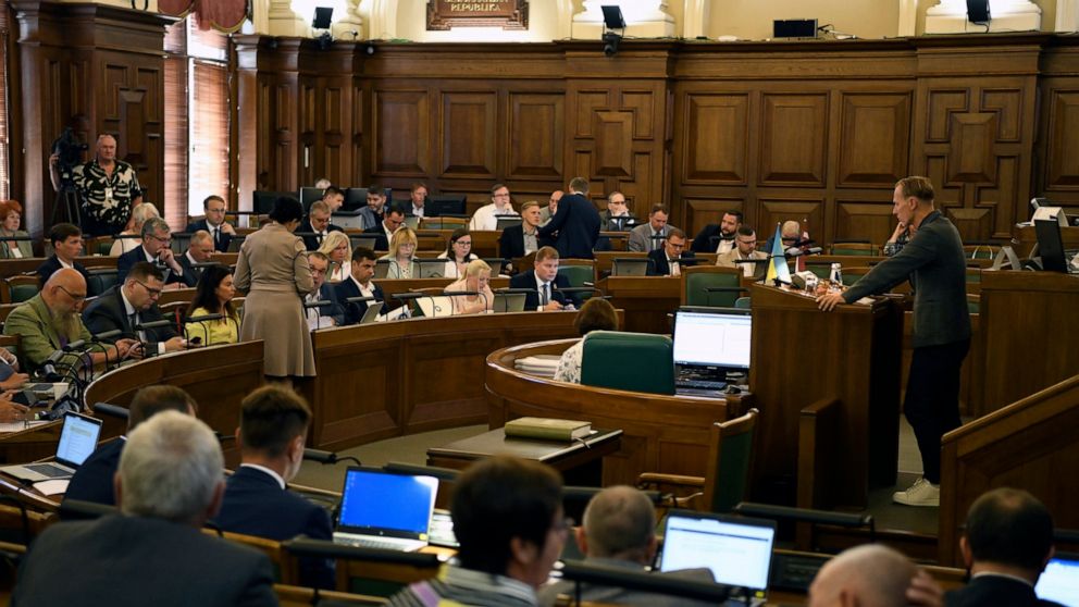 In this handout photo released by the Parliament, Saeima, of the Republic of Latvia, Latvian lawmakers attend a session in Riga, Latvia, Thursday, Aug. 11, 2022. Latvia's Parliament has declared Russia a "state sponsor of terrorism" for attacks on ci