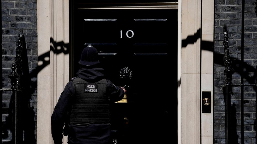 A police officer goes into 10 Downing Street in London, Tuesday, May 24, 2022. British Prime Minister Boris Johnson has been shadowed by career-threatening scandal for months — but so far he has escaped unscathed. This week he faces one more threat t