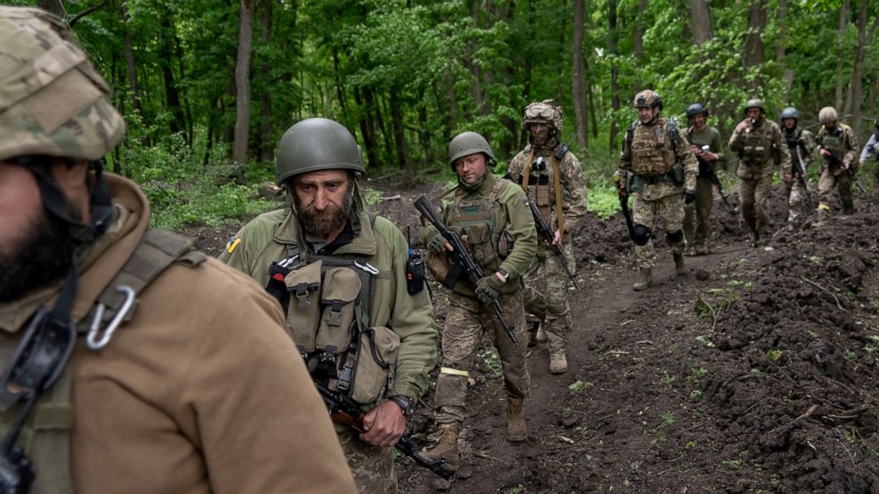 Ukrainian servicemen walk in the forest near a recently retaken village, north of Kharkiv, east Ukraine, Sunday, May 15, 2022. (AP Photo/Mstyslav Chernov)