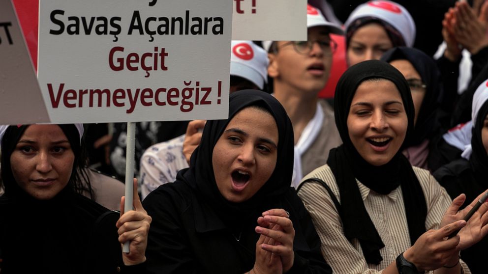 Turkish demonstrators chant slogans while holding a banner that reads: "We will not give way to those who wage war on the family", in the Fatih district of Istanbul, Sunday, Sept. 18, 2022. (AP Photo/Khalil Hamra)