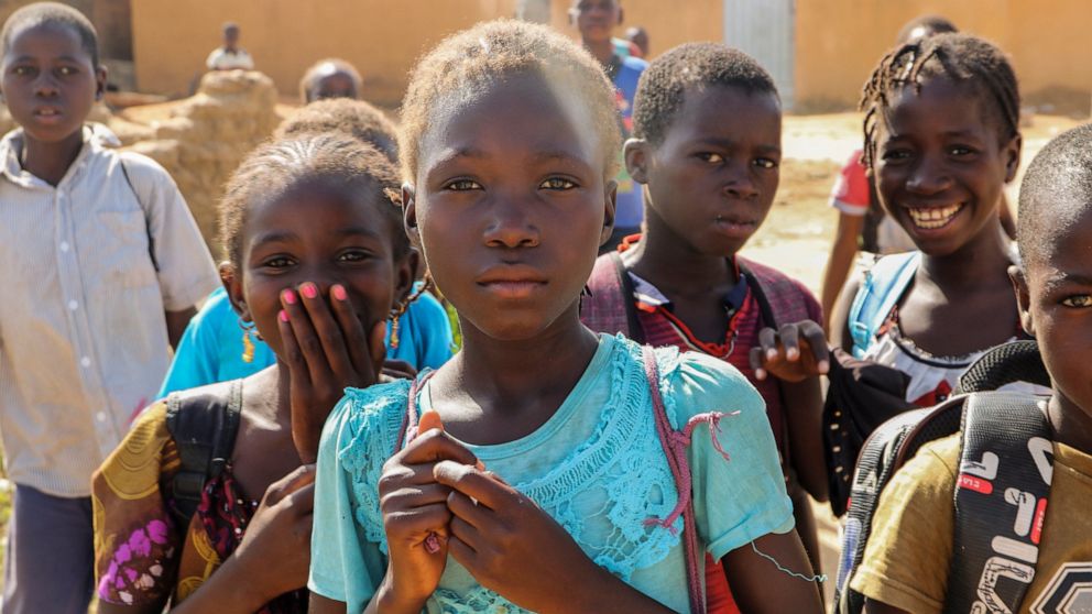 Balkissa Barro, 10, center, walks to school with friends in the Burkina Faso village of Dori Tuesday Oct. 20, 2020. Children returning to school in Burkina Faso's volatile Sahel region, have to practice safety drills to prepare for potential jihadist