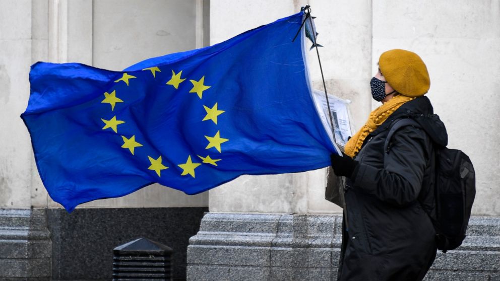 An anti-Brexit demonstrator holds an EU flag in Parliament Square, in London, Wednesday, Dec. 16, 2020. Ursula von der Leyen said Wednesday she saw clear progress in the trade talks with the UK, turning a post-Brexit deal from a fleeting possibility 