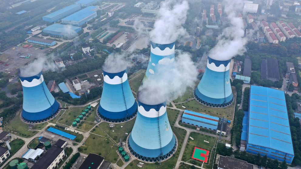 Steam billows out of the cooling towers at a coal-fired power station in Nanjing in east China's Jiangsu province on Monday, Sept. 27, 2021. Global shoppers face possible shortages of smartphones and other goods ahead of Christmas after power cuts to