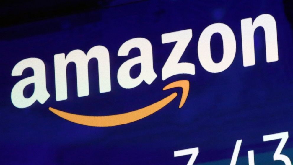 FILE - The logo for Amazon is displayed on a screen at the Nasdaq MarketSite, in New York, Friday, July 27, 2018. Amazon’s British website has backed away from plans to stop accepting Visa credit cards issued in the United Kingdom. The online retaile