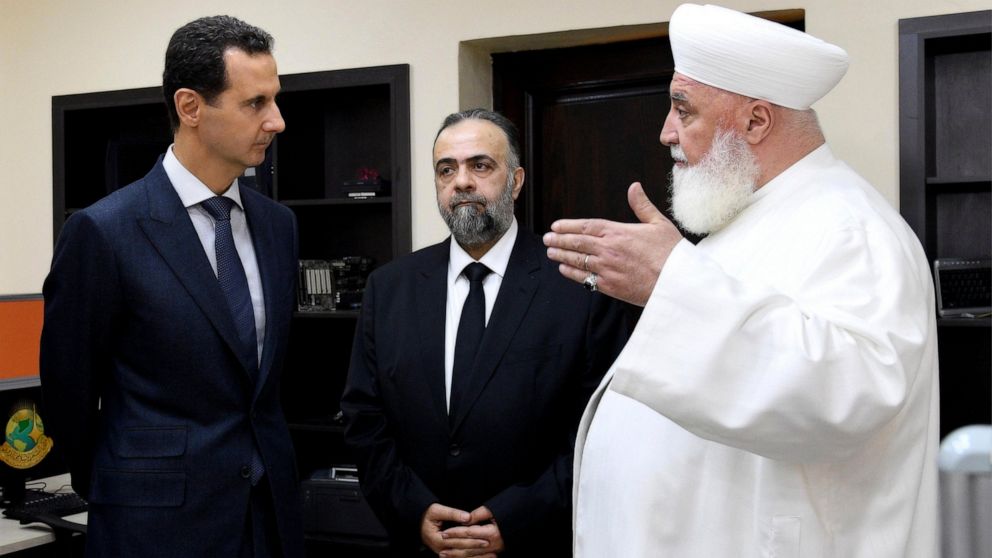 In this photo released on May, 20, 2019 by the Syrian official news agency SANA, shows Syrian President Bashar Assad, left, listens to Damascus Mufti Adnan Afiouni, right, at an Islamic center, in Damascus, Syria. Mufti Afiouni who played a key role 