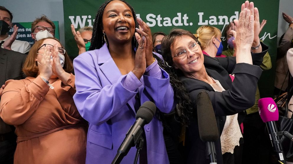 FILE - Aminata Toure, center, applauds after the first forecasts for the state election in Schleswig-Holstein were announced, in Kiel, Germany, May 8, 2022. The daughter of two Malian refugees has become the first black member of a state government i