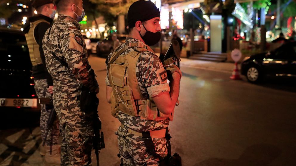 Lebanese security forces wearing protective masks to prevent the spread of coronavirus, as they stand guard at a street full of restaurants where revelers celebrating the New Year Eve, in Beirut, Lebanon, early Friday, Jan. 1, 2021. Lebanon ended the