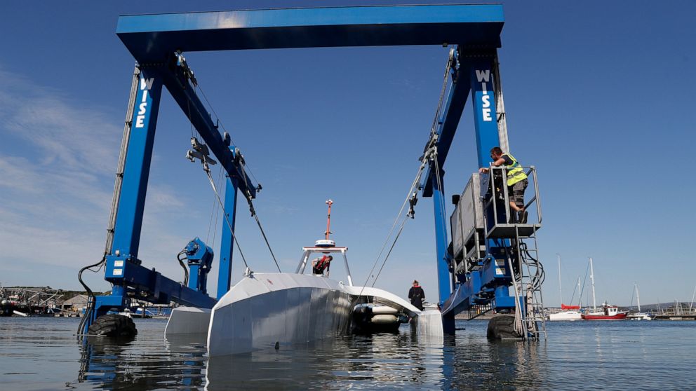 FILE - In this Monday, Sept. 14, 2020 file photo, technicians lower the Mayflower Autonomous Ship into the water at its launch site for it's first outing on water since being built in Turnchapel, Plymouth south west England. Four centuries and one ye