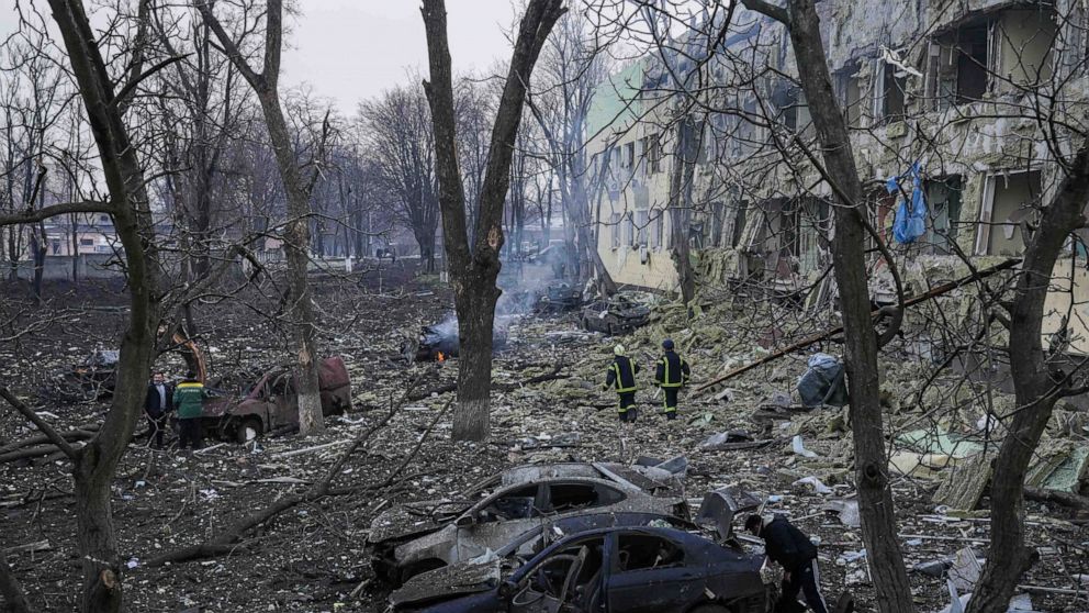 Ukrainian emergency employees work at the side of the damaged by shelling maternity hospital in Mariupol, Ukraine, Wednesday, March 9, 2022. A Russian attack has severely damaged a maternity hospital in the besieged port city of Mariupol, Ukrainian o