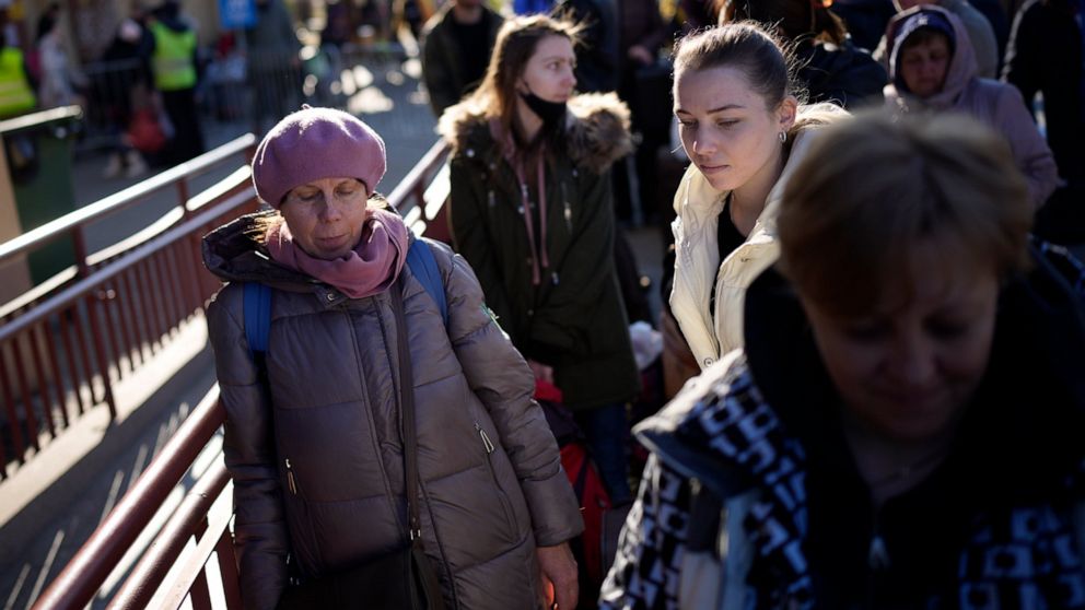 People wait in a line to board a train leaving for Lviv in Ukraine at the train station in Przemysl, Poland, Monday, March 14, 2022. While tens of thousands of people have fled Ukraine every day since Russia's invasion, a small but growing number are