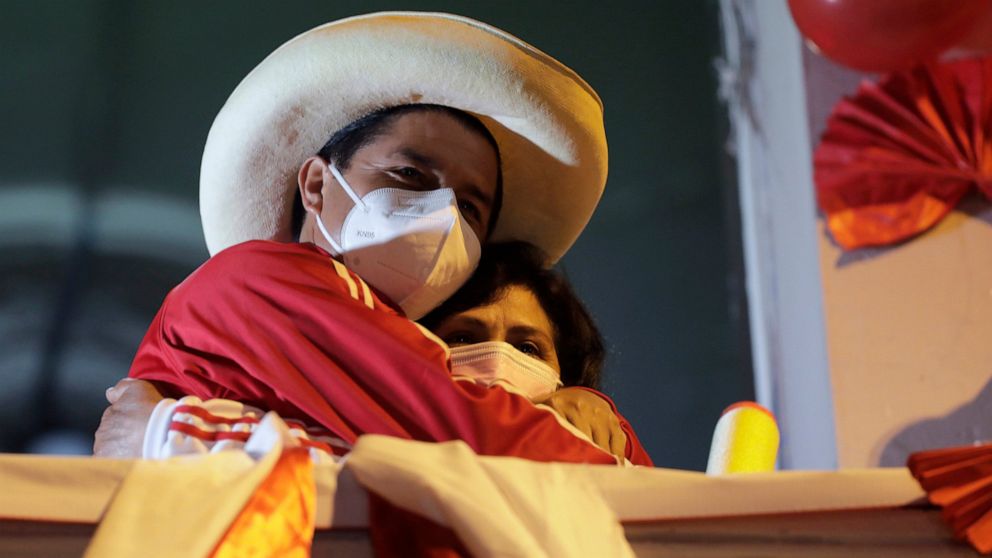 FILE - Pedro Castillo hugs his wife Lilia Paredes Navarro as he stands before supporters at his closing campaign rally in Lima, Peru, June 3, 2021. (AP Photo/Guadalupe Pardo, FIle)