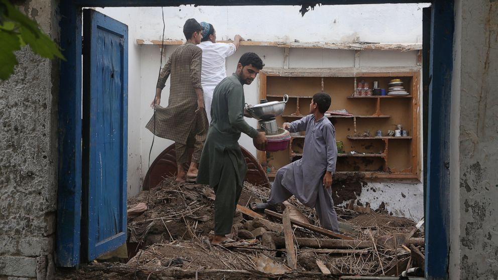 People salvage usable items from their house, after the roof collapsed due to heavy rains, in Peshawar, Pakistan, Thursday, July 28, 2022. The National Disaster Management Authority said Wednesday that 337 people died across the country in rain-relat