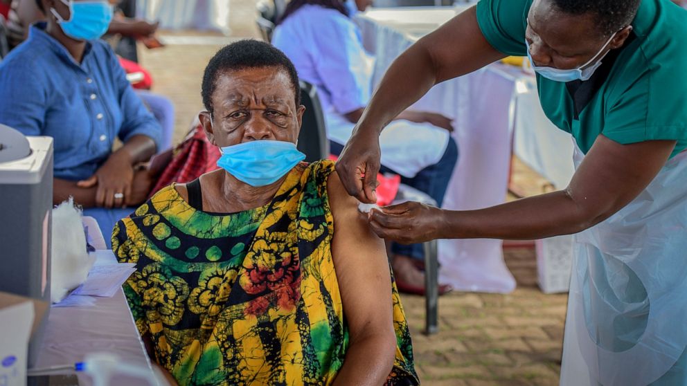 FILE - A woman receives a coronavirus vaccination at the Kololo airstrip in Kampala, Uganda on May 31, 2021. Uganda has its first seven cases of the omicron variant of the coronavirus, a health official confirmed Tuesday, Dec. 7, 2021, saying the var