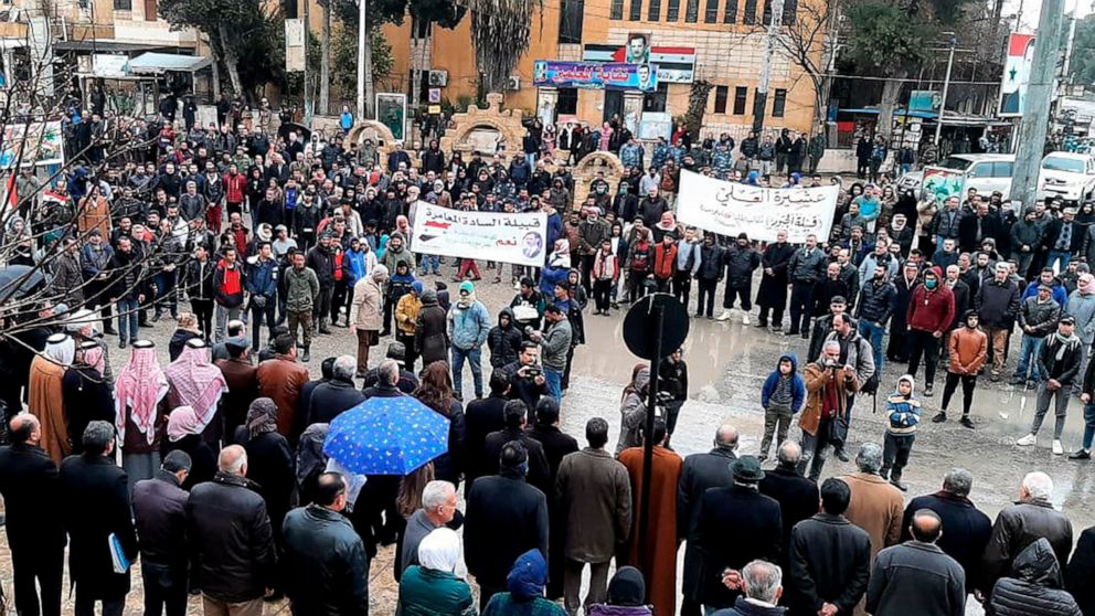 In this photo released by the Syrian official news agency SANA, pro-government demonstrators protest the siege on their neighborhood by Kurdish security forces, in Hassakeh, Syria, Sunday, Jan. 31, 2021. The state news agency SANA said one Syrian was