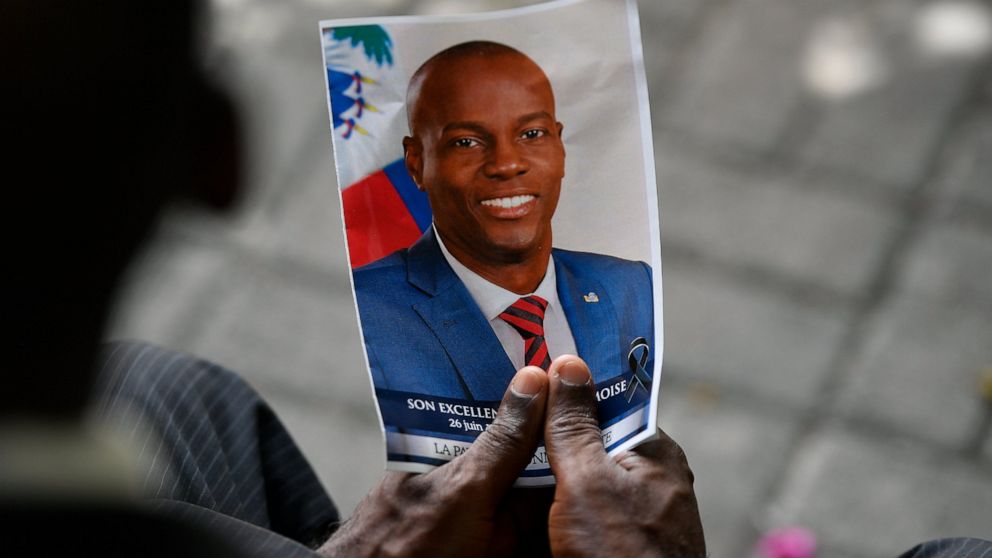 FILE - A person holds a photo of late Haitian President Jovenel Moise during his memorial ceremony at the National Pantheon Museum in Port-au-Prince, Haiti, Tuesday, July 20, 2021. Authorities in the Dominican Republic said Monday, Jan. 10, 2022, tha