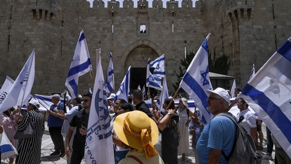 Israelis wave national flags in front of Damascus Gate outside Jerusalem's Old City to mark Jerusalem Day, an Israeli holiday celebrating the capture of the Old City during the 1967 Mideast war. Sunday, May 29, 2022. Israel claims all of Jerusalem as