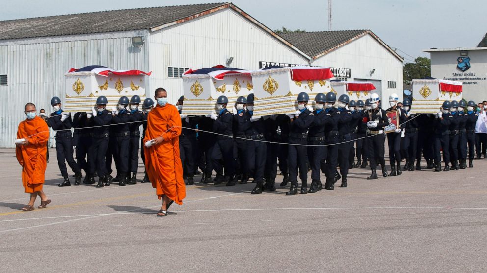 Thai Buddhist monks walk in front of coffins of victims from the Sunday night sinking of a Thai Navy warship as they were carried in a repatriation ceremony with religious rites in Prachuap Khiri Khan province, Thailand, Thursday, Dec. 22, 2022, befo