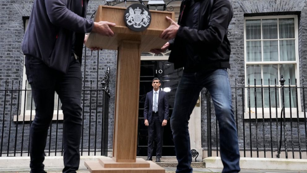 FILE - New British Prime Minister Rishi Sunak, centre, poses for the media as the pulpit is moved after his speech at Downing Street in London, Tuesday, Oct. 25, 2022, after returning from Buckingham Palace where he was formally appointed to the post