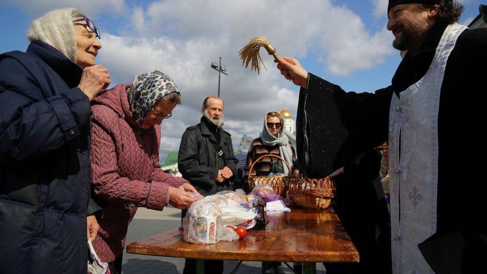 An Orthodox priest blesses traditional Easter cakes and painted eggs in preparation for Easter, outside a church in Minsk, Belarus, Saturday, April 18, 2020. For Orthodox Christians, this is normally a time of reflection, communal mourning and joyful