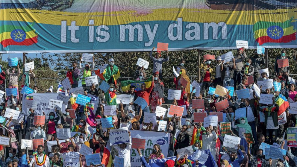 FILE - Ethiopians protest against international pressure on the government over the conflict in Tigray, below a banner referring to The Grand Ethiopian Renaissance Dam, at a demonstration organised by the city mayor's office held at a stadium in the 