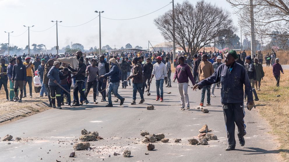 People demonstrate in the South African city of Krugersdorp Thursday Aug. 4, 2022. Community members in the assaulted suspected illegal miners and set fire to their camps on Thursday in an outpouring of anger following the alleged gang rapes of eight