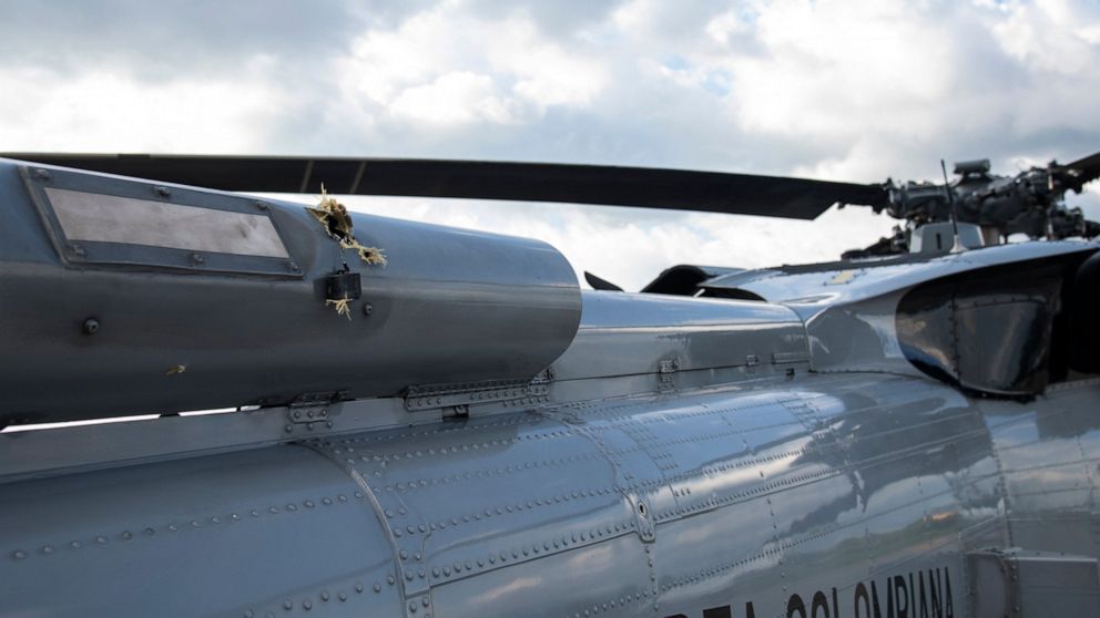 In this photo released by Colombia's Presidency, bullet holes are seen on the fuselage of a Colombian Air Force helicopter that were fired while Colombia's President Ivan Duque and members of his cabinet were traveling on the helicopter, at the airpo
