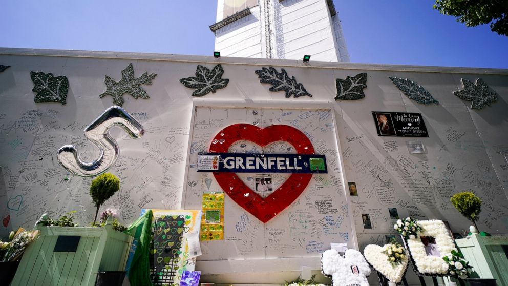 Flowers and tributes left outside the remains of the Grenfell Tower, in London, Tuesday, June 14, 2022. Tuesday marks the fifth anniversary of the fire that killed 72 people. (AP Photo/Alberto Pezzali)