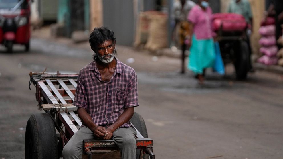 A daily wage laborer waits for work at a wholesale market in Colombo, Sri Lanka, Sunday, June 26, 2022. Sri Lankans have endured months of shortages of food, fuel and other necessities due to the country's dwindling foreign exchange reserves and moun
