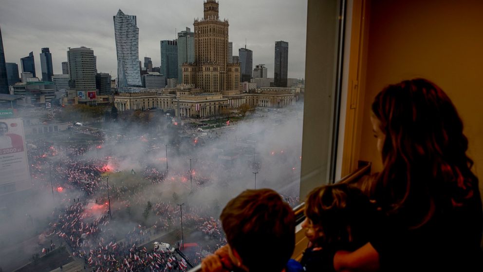 Children watch from a window as thousands of people have gathered in the city center for a yearly Independence Day march organized by nationalist groups that has been marked by violence in past years in Warsaw, Poland, Friday, Nov. 11, 2022. (AP Phot