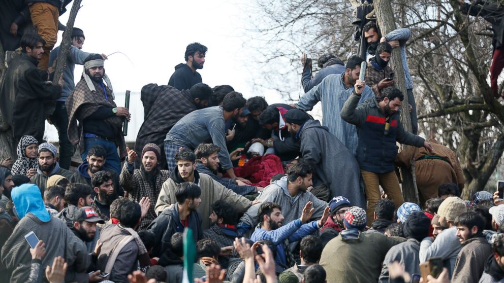 Kashmiri villagers assemble near the body of rebel commander Zeenatul Islam during his funeral procession in Sugan village 61 kilometers (38 miles) south of Srinagar, Indian controlled Kashmir, Sunday, Jan. 13, 2019. Massive anti-India protests and c