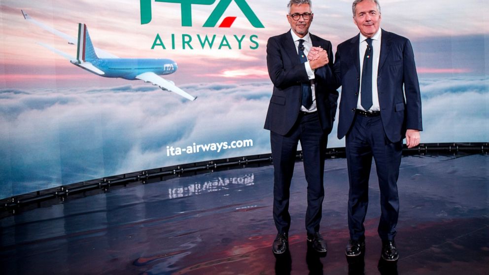 Fabio Lazzerini, left, CEO of new national carrier ITA, poses with President Alfredo Altavilla during the presentation in Rome, Friday, Oct. 15, 2021. Italy’s new national carrier ITA made its inaugural flight Friday and unveiled its new name and log