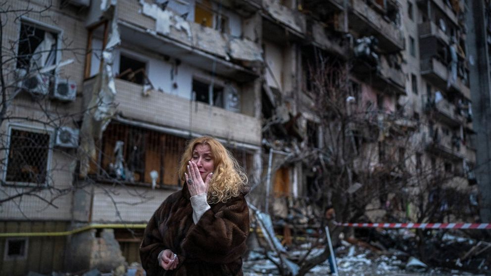 FILE - Natali Sevriukova reacts next to her house following a rocket attack the city of Kyiv, Ukraine, on Feb. 25, 2022. By ending 77 years of almost uninterrupted peace in Europe, war in Ukraine war has joined the dawn of the nuclear age and the bir