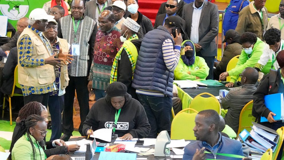 The Electoral Commission (IEBC) Chairman, Wafula Chebukati, middle in red shirt, and IEBC commissioners at the National Tallying Centre in Bomas of Kenya, Nairobi, Kenya, Sunday, Aug. 14, 2022. Kenyans are waiting for the results of a close president