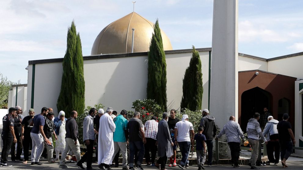 FILE - In this March 23, 2019 file photo, worshippers prepare to enter the Al Noor mosque following the previous week's mass shooting in Christchurch, New Zealand. A comprehensive report released Tuesday, Dec. 8, 2020 into the 2019 Christchurch mosqu
