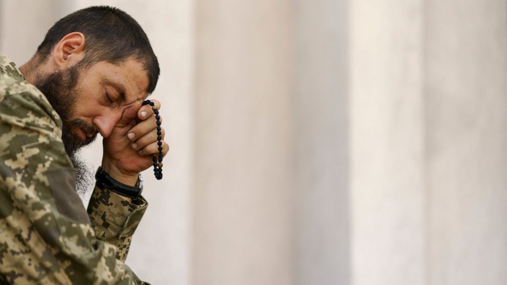 A Ukrainian serviceman prays during a service at St. Michael's Ukrainian Orthodox Church of the Moscow Patriarchate on Savior of the Honey Feast Day in Pokrovsk, Donetsk region, eastern Ukraine, Sunday, Aug. 14, 2022. (AP Photo/David Goldman)