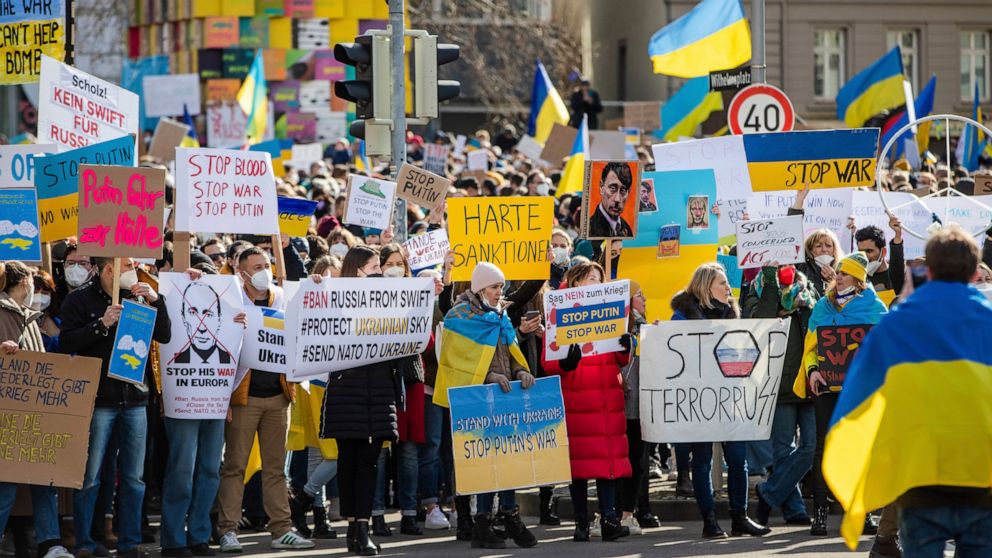 Numerous people demonstrate with signs and flags on Wilhelmsplatz in Stuttgart, Germany, against Russia's military deployment in Ukraine on Saturday, Feb. 26, 2022. [Christoph Schmidt/dpa via AP)