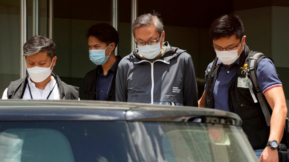 Police officers escort Cheung Kim-hung, right, CEO and Executive Director of Next Digital Ltd at Apple Daily headquarters in Hong Kong, Thursday, June 17, 2021. Hong Kong police on Thursday morning arrested the chief editor and four other senior exec