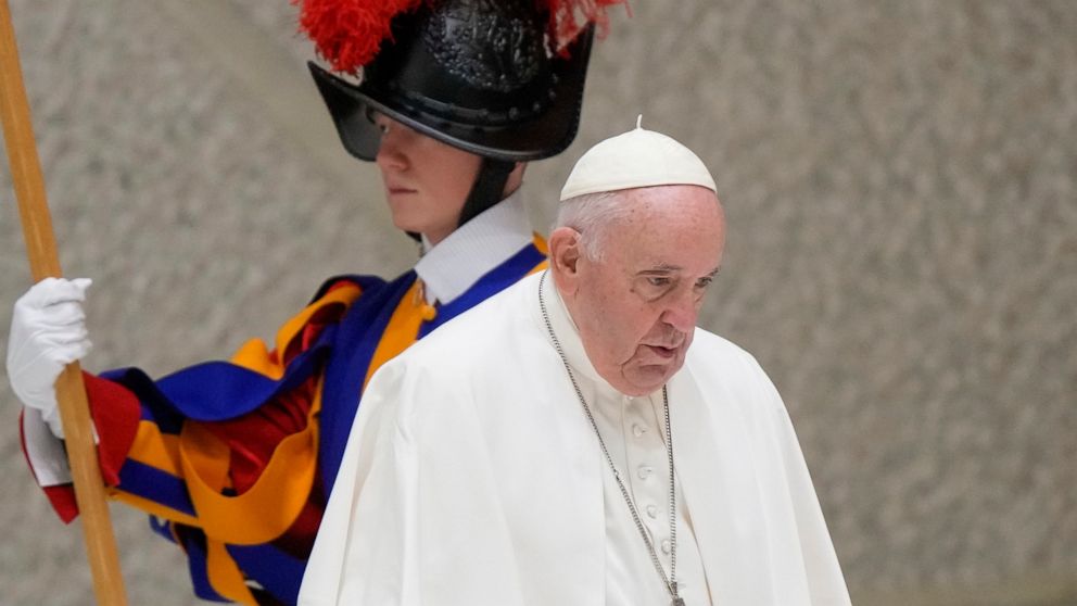 Pope Francis walks past a Vatican Swiss Guard as he arrives to meet with members of the Italian Schools for Peace Network in the Pope Paul VI hall at the Vatican, Monday, Nov. 28, 2022. (AP Photo/Andrew Medichini)