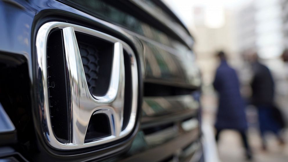 FILE - People walk near the logo of Honda Motor Company at a showroom on Feb. 8, 2022, in Tokyo. Honda’s fiscal second quarter profit rose nearly 14% on a weak yen that boosts Japanese exporters’ earnings, and strong demand for its vehicles and motor