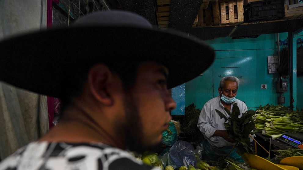 A man shops for vegetables at a market in Mexico City, Tuesday, Aug. 9, 2022. Mexico's annual inflation rate rose to 8.15% in July, driven largely by the rising price of food, according to government data released Tuesday. (AP Photo/Fernando Llano)