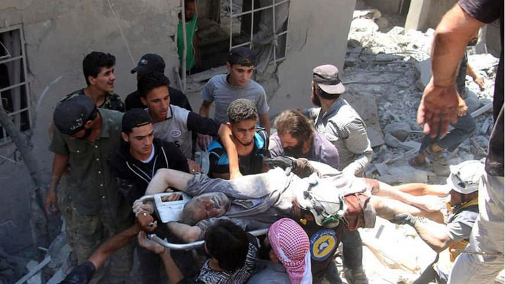 This photo provided by the Syrian Civil Defense White Helmets, which has been authenticated based on its contents and other AP reporting, shows Syrian White Helmet civil defense workers and civilians carry an injured man on a stretcher after an airst